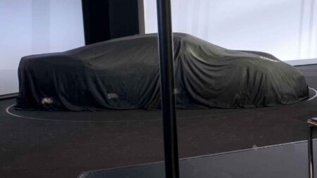 Porsche Mission S Breaks Cover in a Shadowy Investor Presentation Image Porsche Mission S concept hidden beneath a black cover showing a low aggressive silhouette