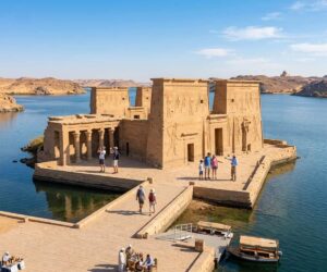 Feluccas sailing on the Nile in Aswan with desert hills and islands in the background