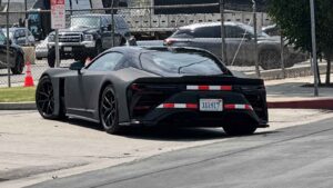Toyota GR GT test vehicle in matte black seen from the rear quarter on a public road