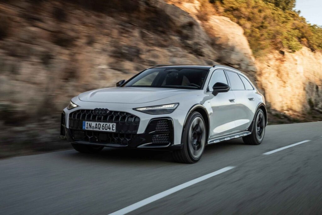 Audi A6 allroad driving on a road in a rugged luxury wagon setting