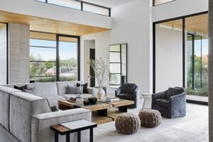 A refined living room with wool carpet, linen curtains, timber furniture and layered tactile materials