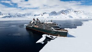Expedition cruise ship sailing near icebergs in a remote polar landscape